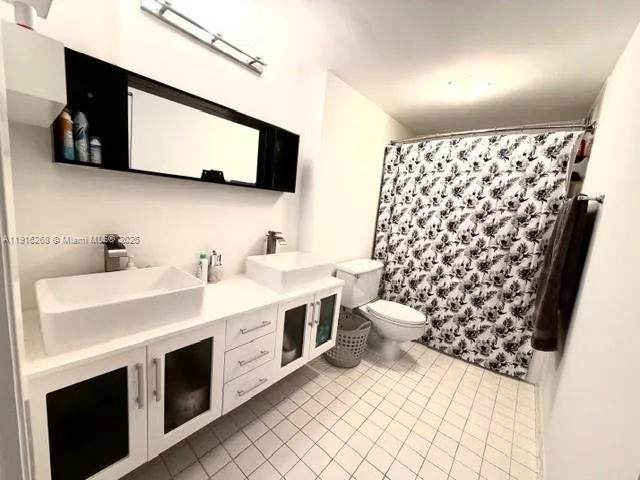 a bathroom with a sink toilet and mirror
