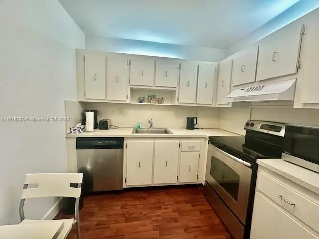 a kitchen with granite countertop white cabinets and white appliances