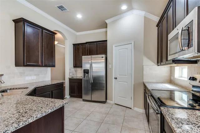 a kitchen with stainless steel appliances granite countertop a sink stove and refrigerator