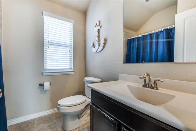 a bathroom with a sink a toilet and a window