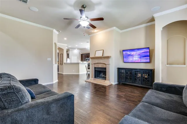 a living room with furniture a fireplace and wooden floor