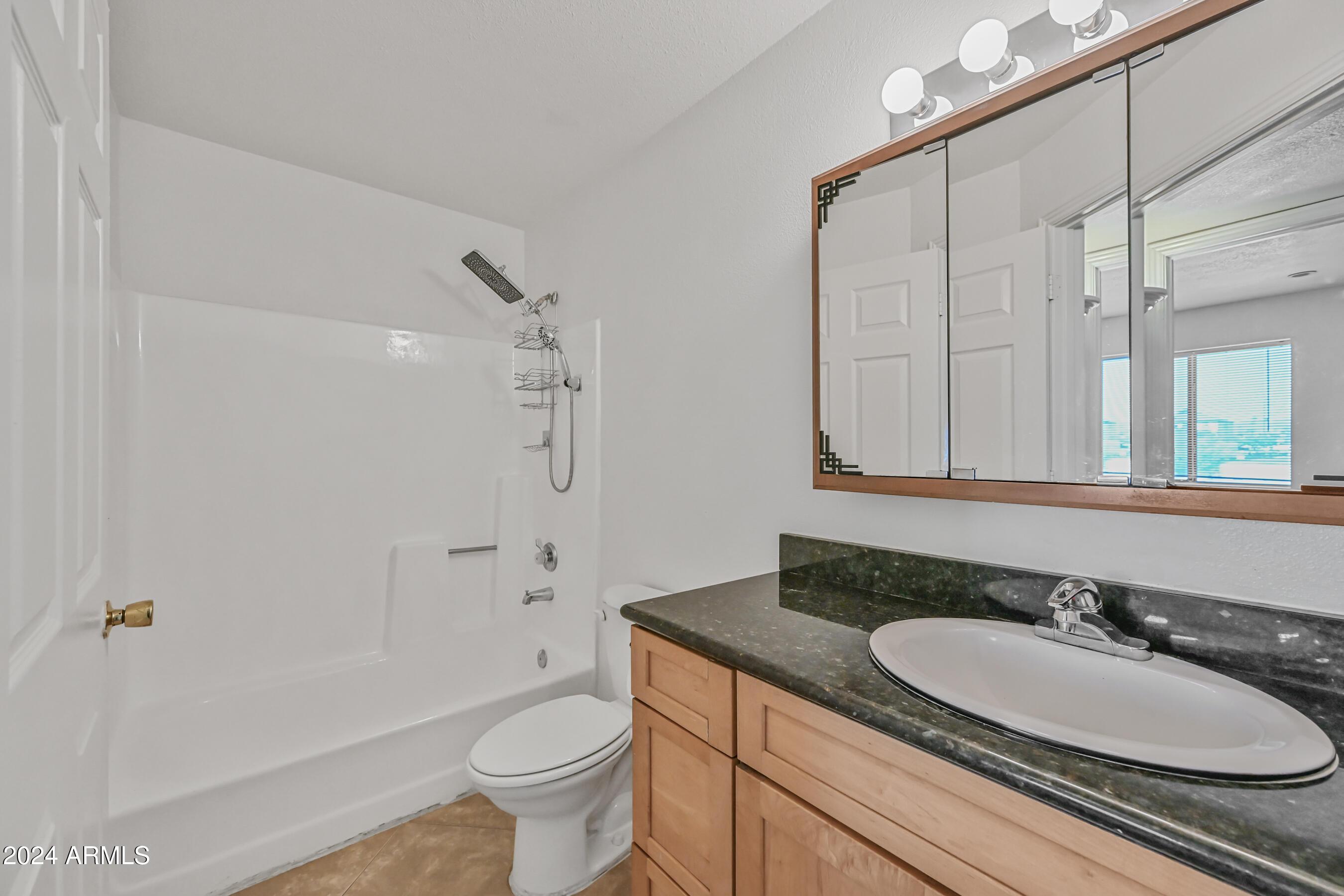1234 North 36th Street, Unit 209 Phoenix, AZ 85008 - Photo 13 of 15 a bathroom with a granite countertop sink toilet and shower