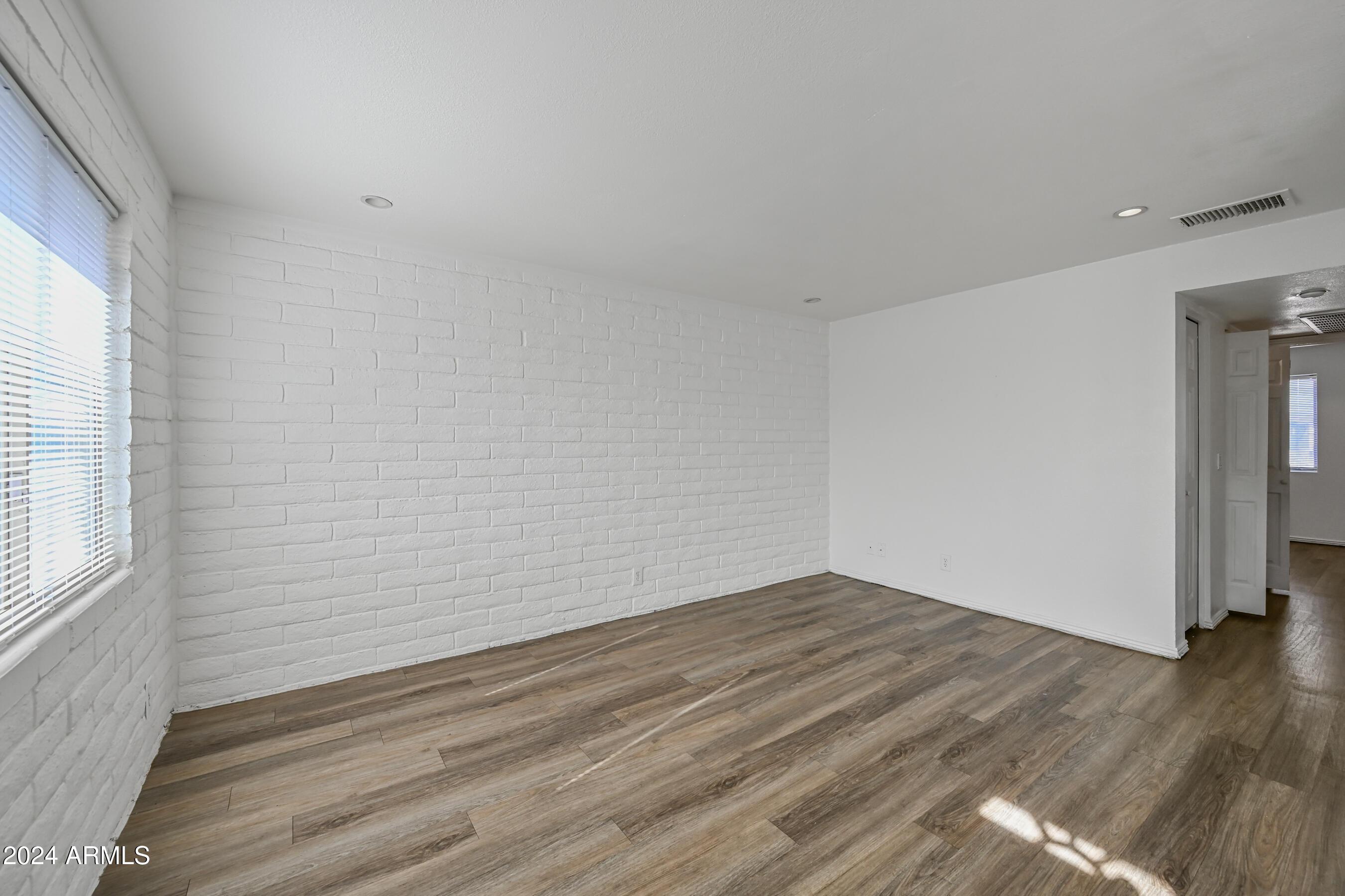 1234 North 36th Street, Unit 209 Phoenix, AZ 85008 - Photo 5 of 15 a view of an empty room with wooden floor and a window