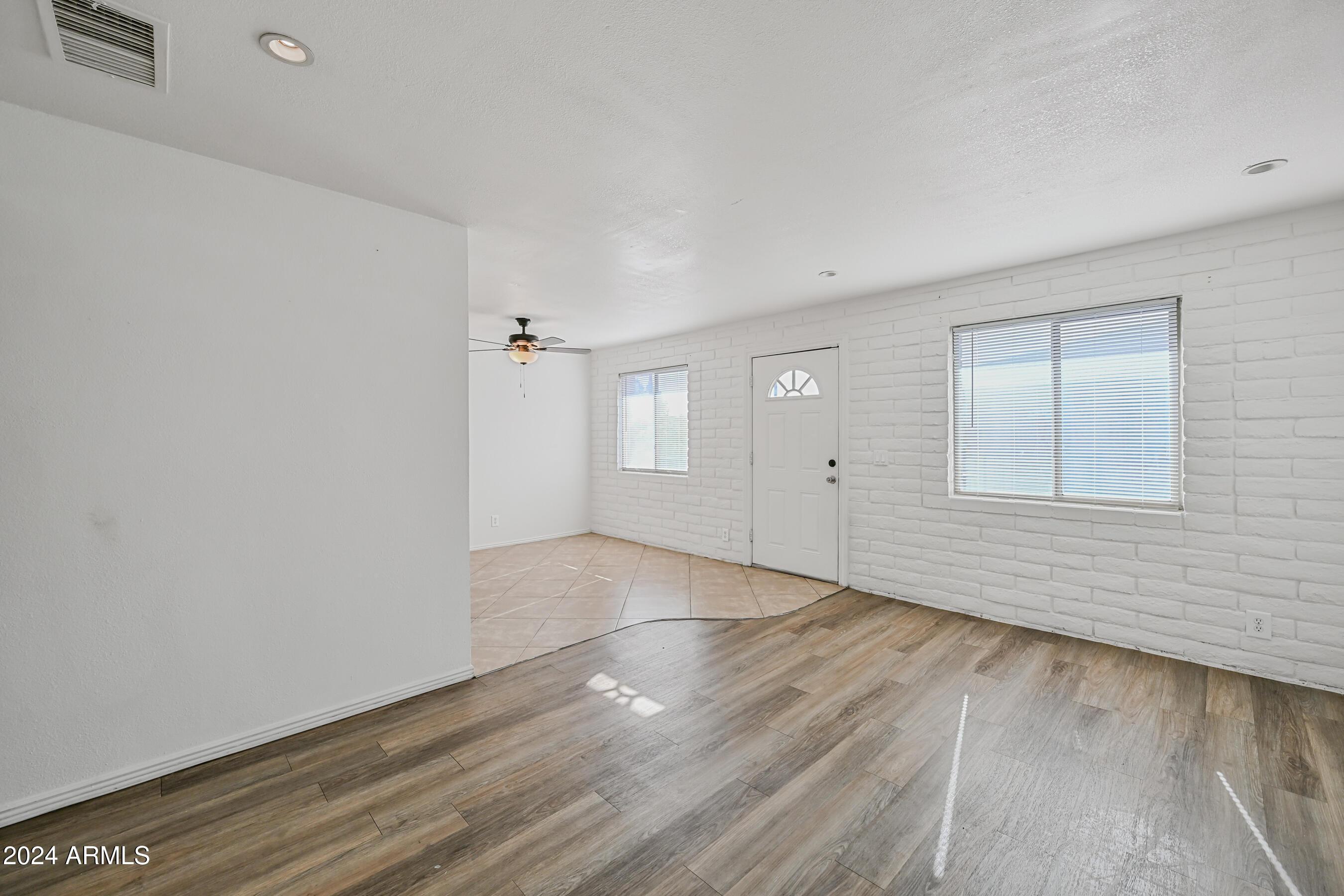 1234 North 36th Street, Unit 209 Phoenix, AZ 85008 - Photo 6 of 15 an empty room with wooden floor and windows