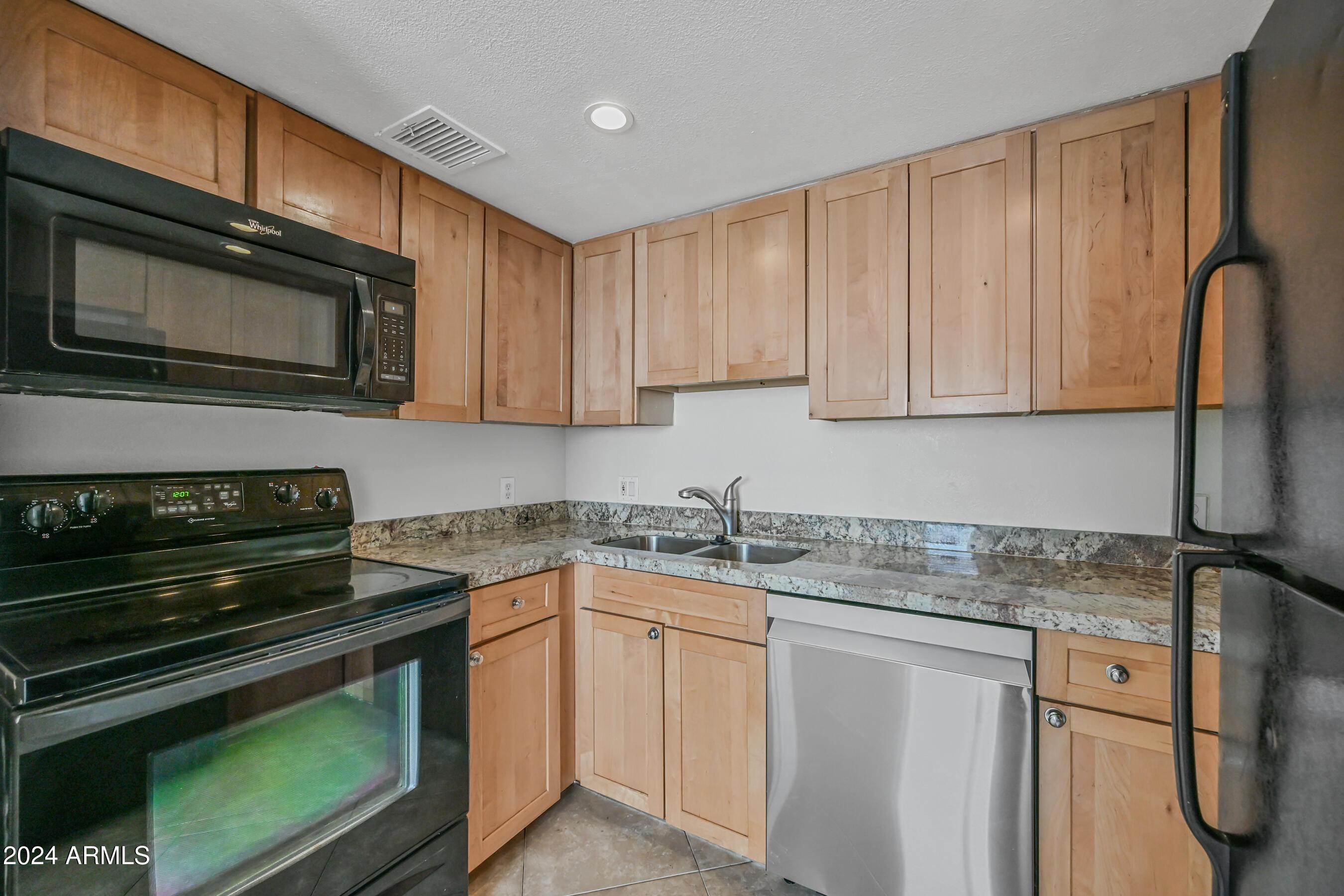 1234 North 36th Street, Unit 209 Phoenix, AZ 85008 - Photo 8 of 15 a kitchen with stainless steel appliances granite countertop a stove microwave and sink