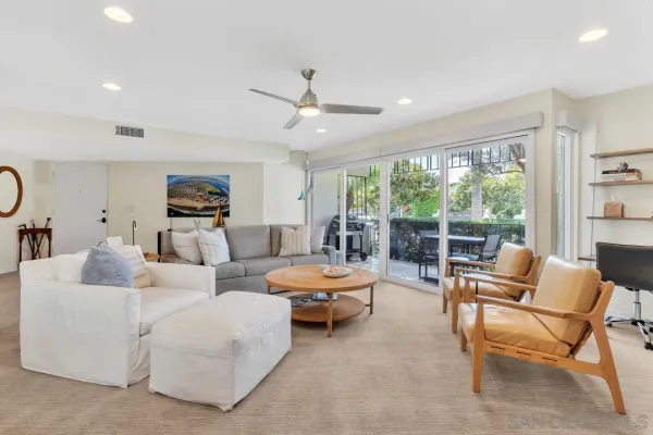 a living room with furniture kitchen view and a chandelier