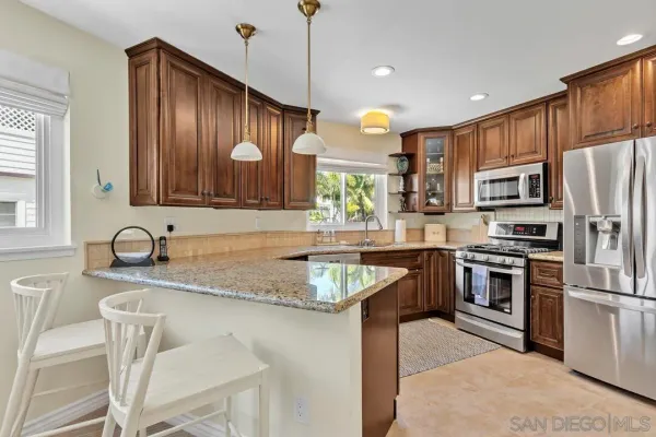 a kitchen with stainless steel appliances granite countertop a sink refrigerator and microwave