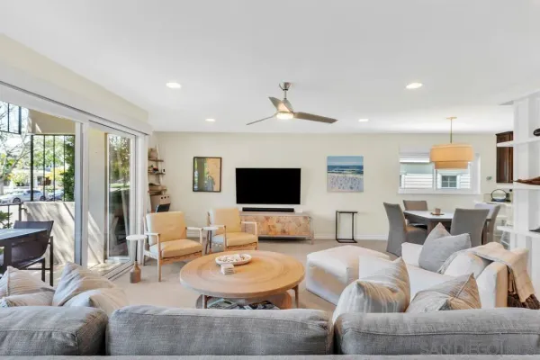 a living room with furniture a flat screen tv and a large window