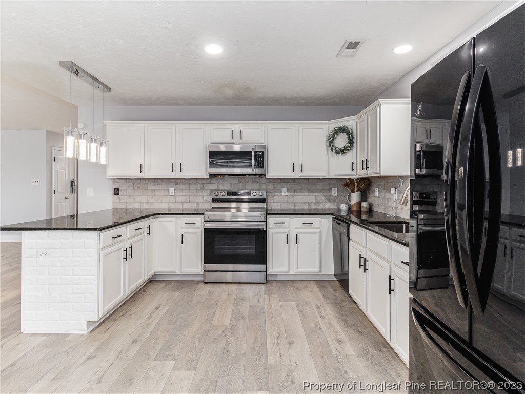 1964 Yellowbrick Road Fayetteville, NC 28314 - Photo 14 of 37 a large kitchen with stainless steel appliances granite countertop a stove a sink dishwasher and a refrigerator