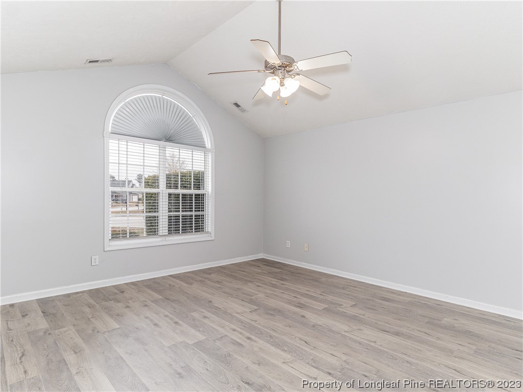 1964 Yellowbrick Road Fayetteville, NC 28314 - Photo 15 of 37 an empty room with wooden floor fan and windows