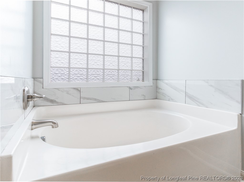 1964 Yellowbrick Road Fayetteville, NC 28314 - Photo 20 of 37 a white bath tub sitting in a bathroom next to a window