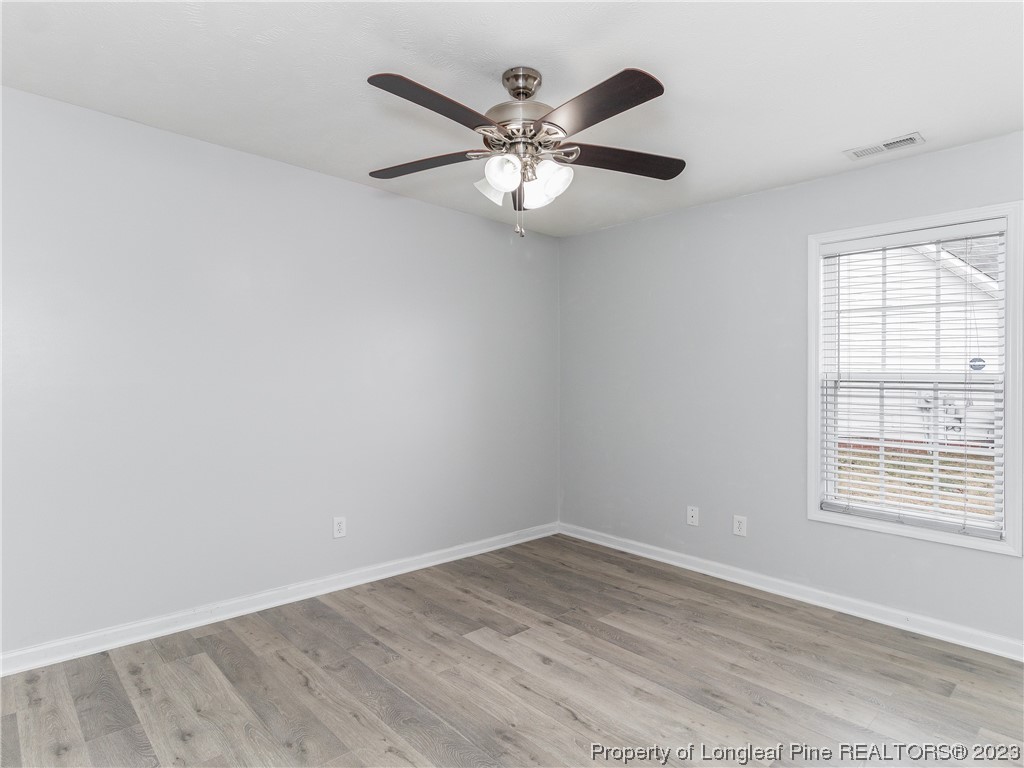 1964 Yellowbrick Road Fayetteville, NC 28314 - Photo 23 of 37 an empty room with wooden floor fan and windows