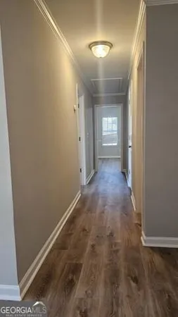 a view of a hallway with wooden floor and a window
