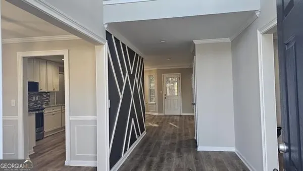 a view of a hallway with wooden floor and staircase