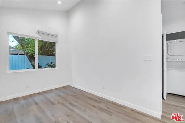 an empty room with wooden floor and a window