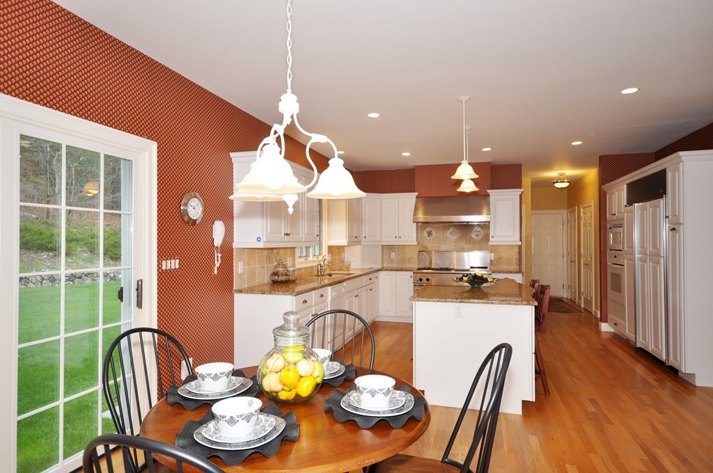 85 Wheeler Road Stow, MA 01775 - Photo 9 of 24 a kitchen with a table chairs stove and wooden floor
