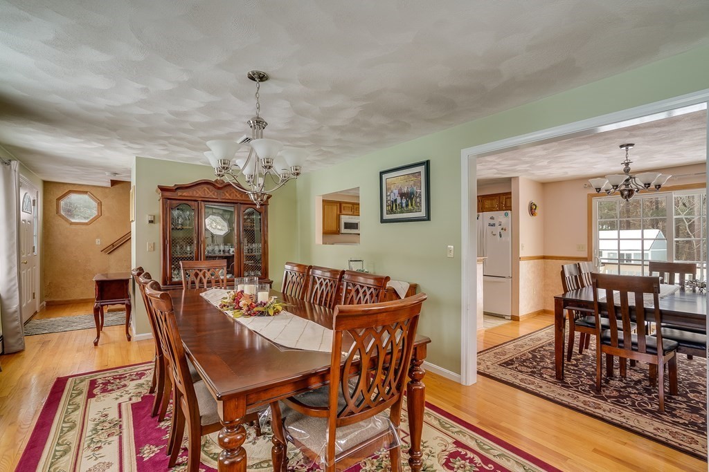 1109 Whipple Road Tewksbury, MA 01876 - Photo 13 of 25 a dining room with furniture a chandelier and wooden floor