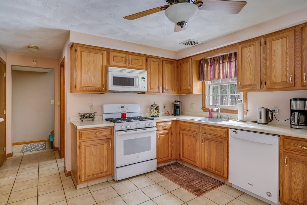 1109 Whipple Road Tewksbury, MA 01876 - Photo 16 of 25 a kitchen with a sink window and cabinets