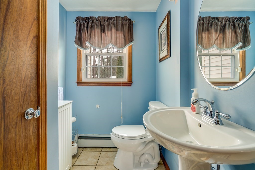 1109 Whipple Road Tewksbury, MA 01876 - Photo 19 of 25 a bathroom with a toilet a sink and a mirror