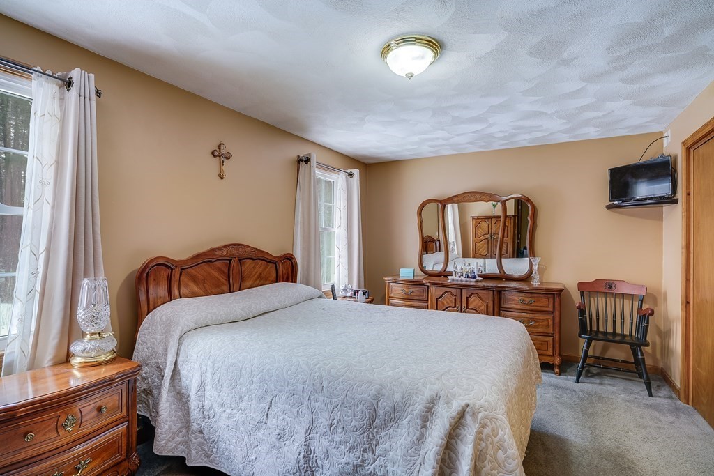 1109 Whipple Road Tewksbury, MA 01876 - Photo 9 of 25 a bedroom with a bed and a flat screen tv