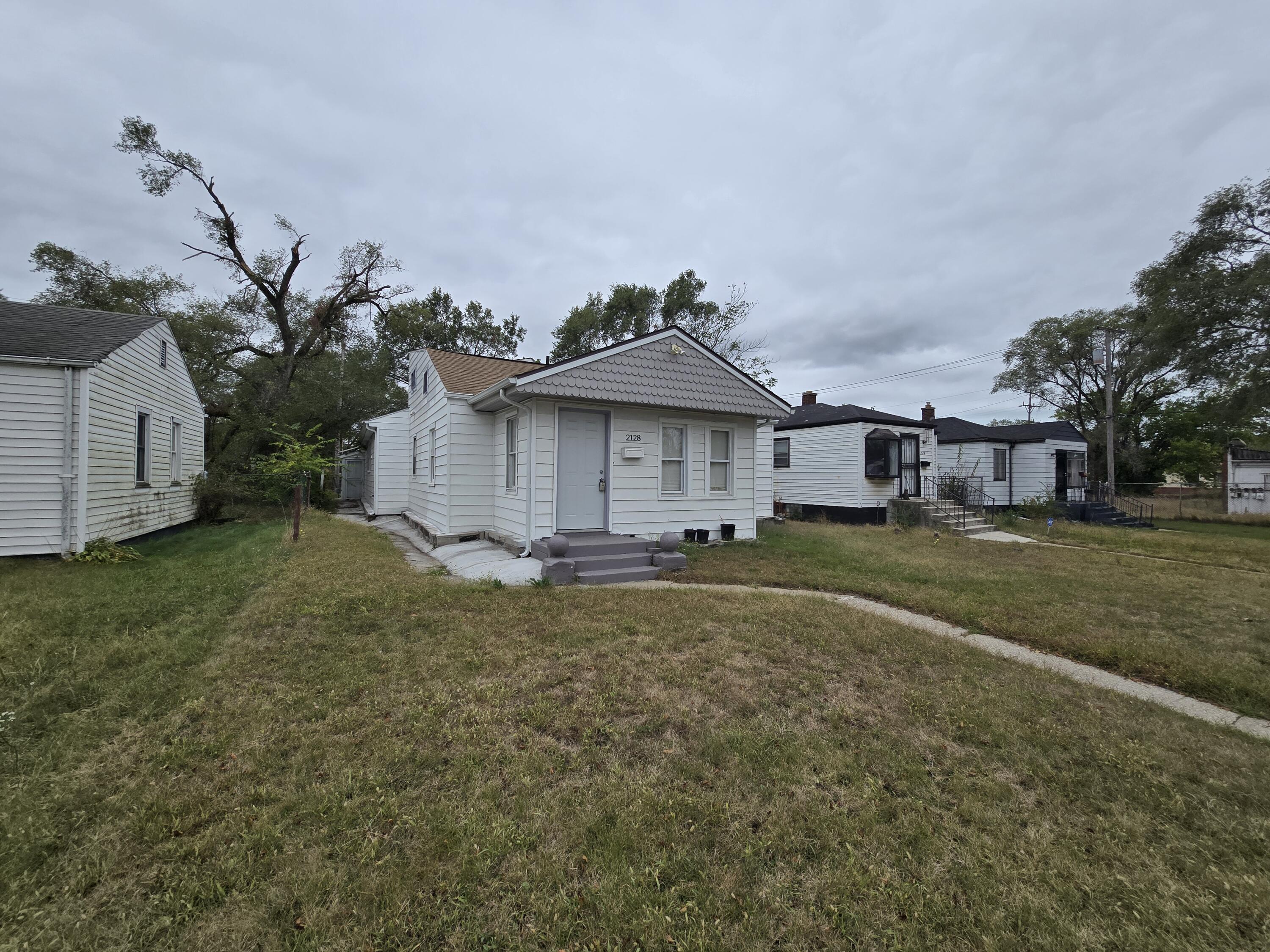 2128 Tennessee Street Gary, IN 46407 - Photo 1 of 26 a front view of a house with a garden