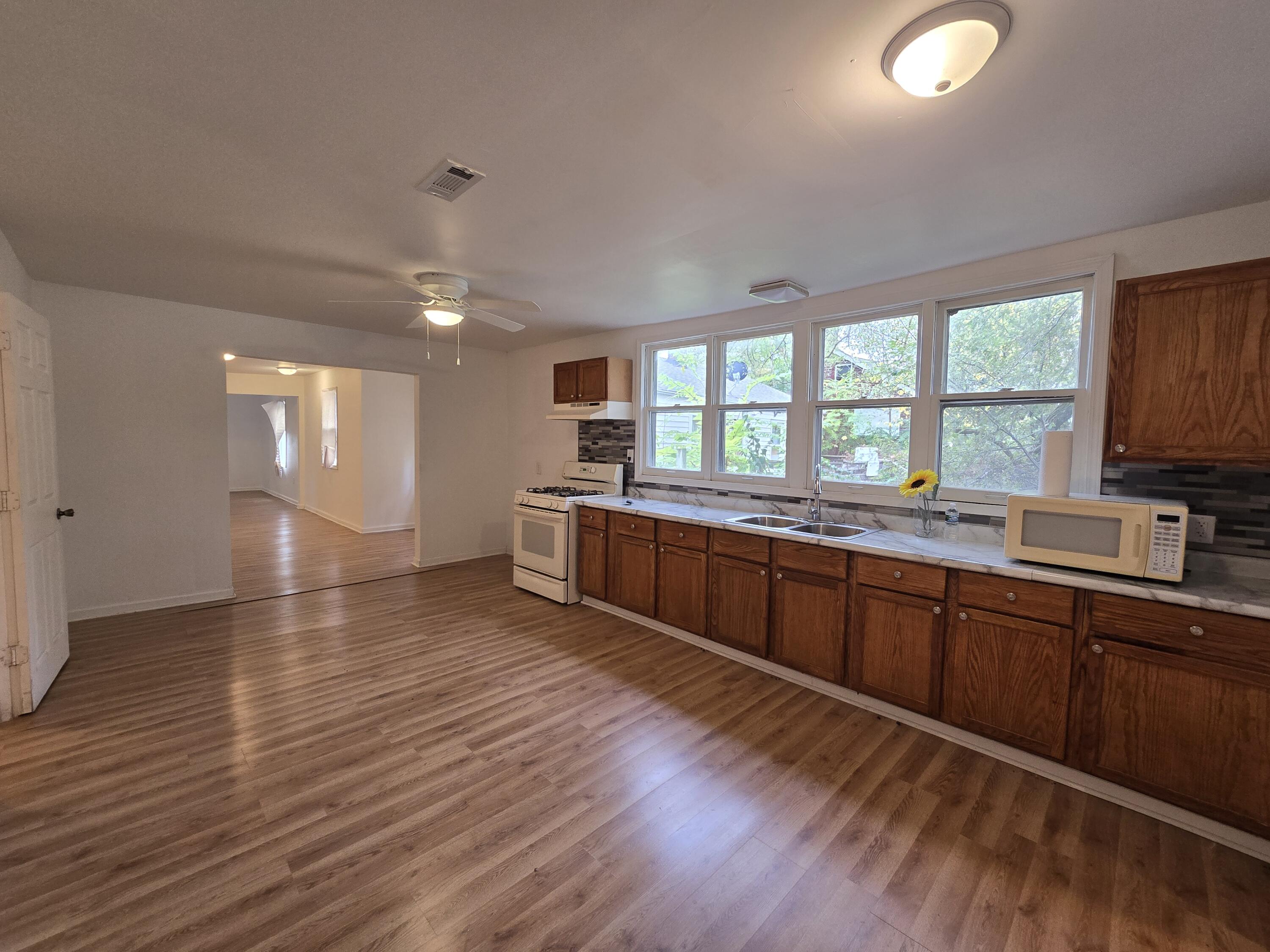 2128 Tennessee Street Gary, IN 46407 - Photo 16 of 26 a kitchen with stainless steel appliances granite countertop a sink cabinets and wooden floor