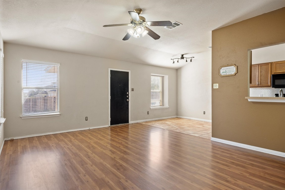 203 Altamont Street Hutto, TX 78634 - Photo 2 of 14 a view of an empty room with a window and wooden floor