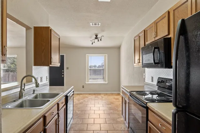 a kitchen that has a sink a stove and a microwave