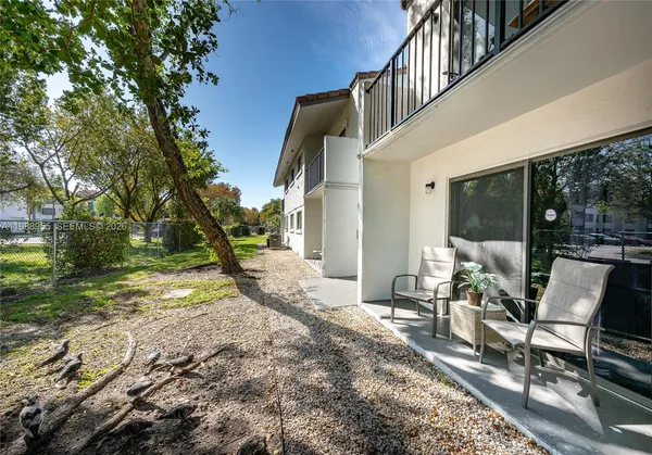 a view of swimming pool with lawn chairs and plants