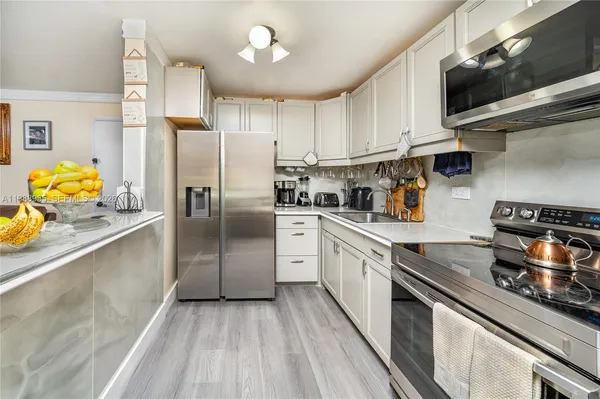 a kitchen with stainless steel appliances granite countertop a sink a stove and a refrigerator