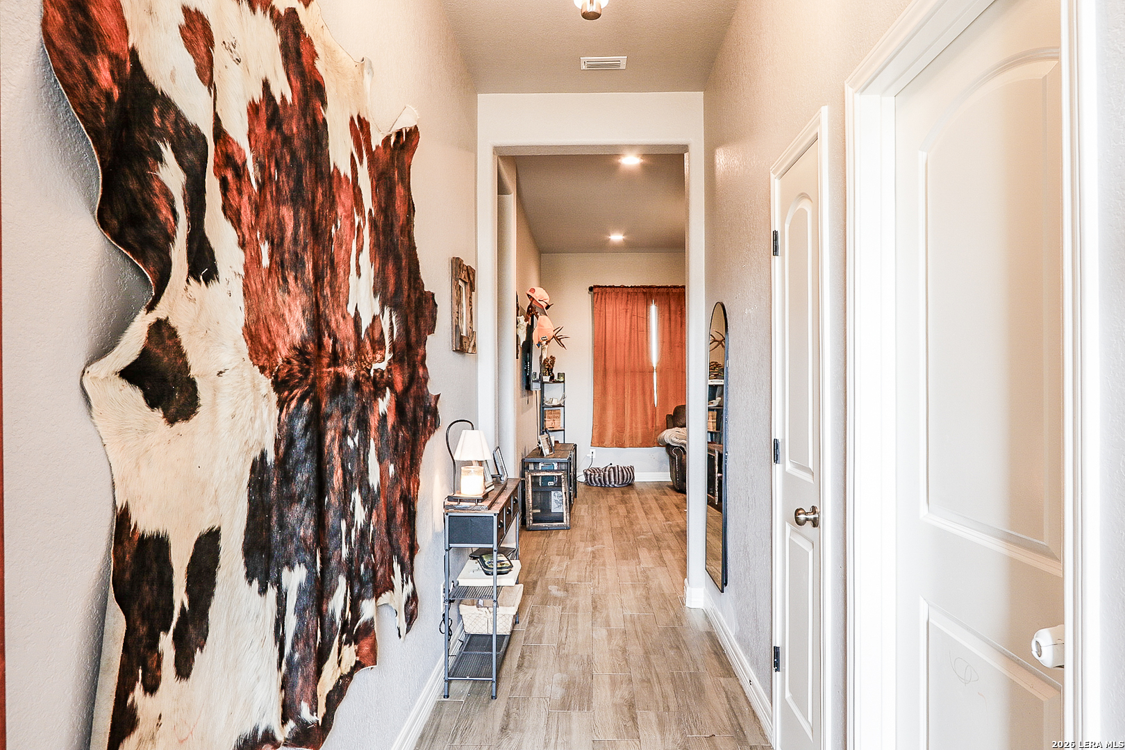 281 Legend Hills Uvalde, TX 78801 - Photo 8 of 24 a view of a hallway with wooden floor and a bathroom