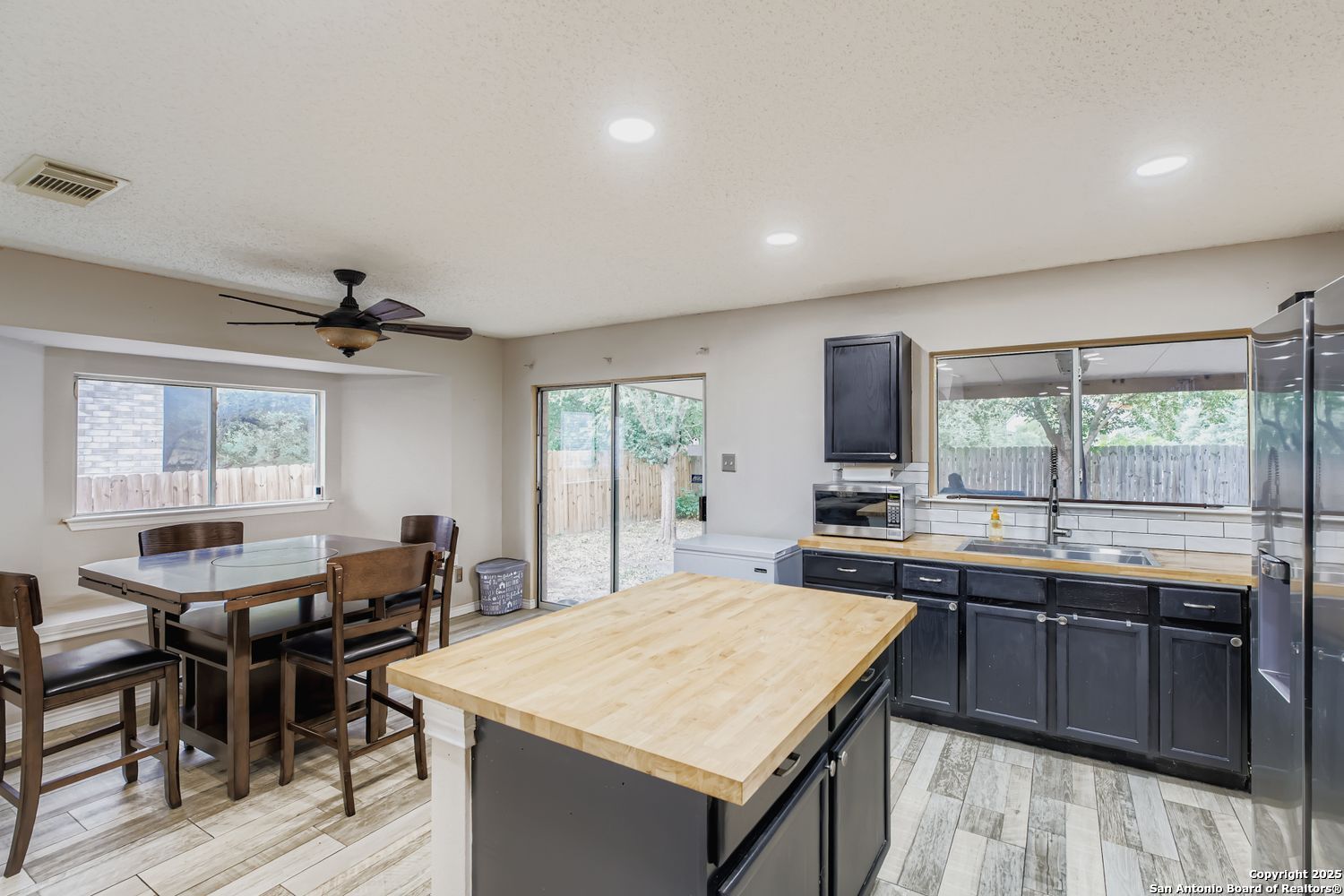 8614 Cross Spring San Antonio, TX 78251 - Photo 11 of 24 a kitchen with a stove a sink a dining table and chairs