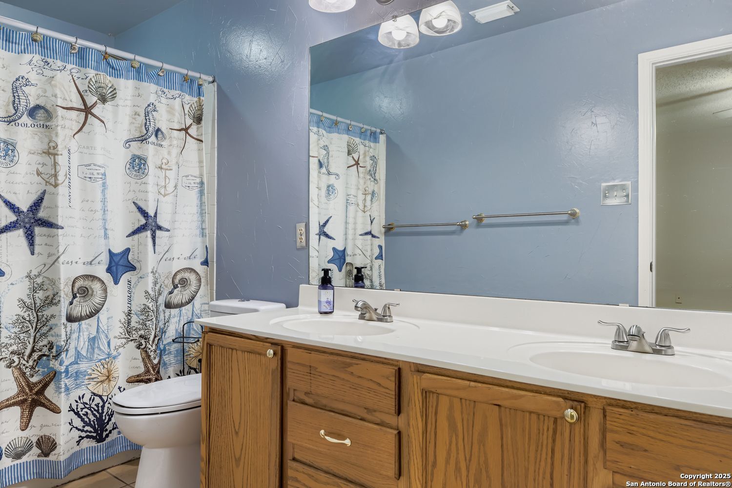 8614 Cross Spring San Antonio, TX 78251 - Photo 15 of 24 a bathroom with a granite countertop sink a toilet and a mirror