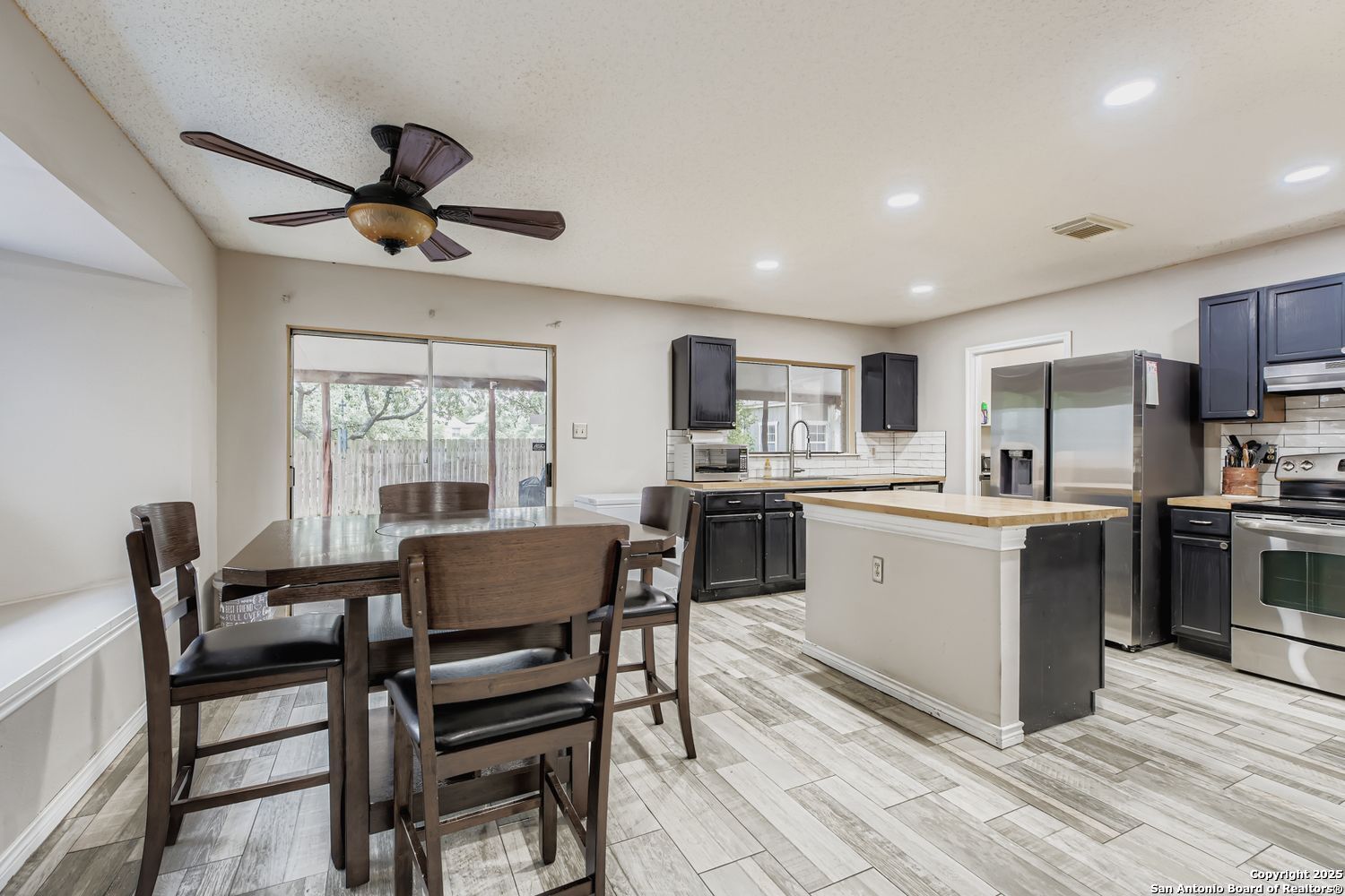 8614 Cross Spring San Antonio, TX 78251 - Photo 6 of 24 a kitchen with a dining table chairs appliances and cabinets