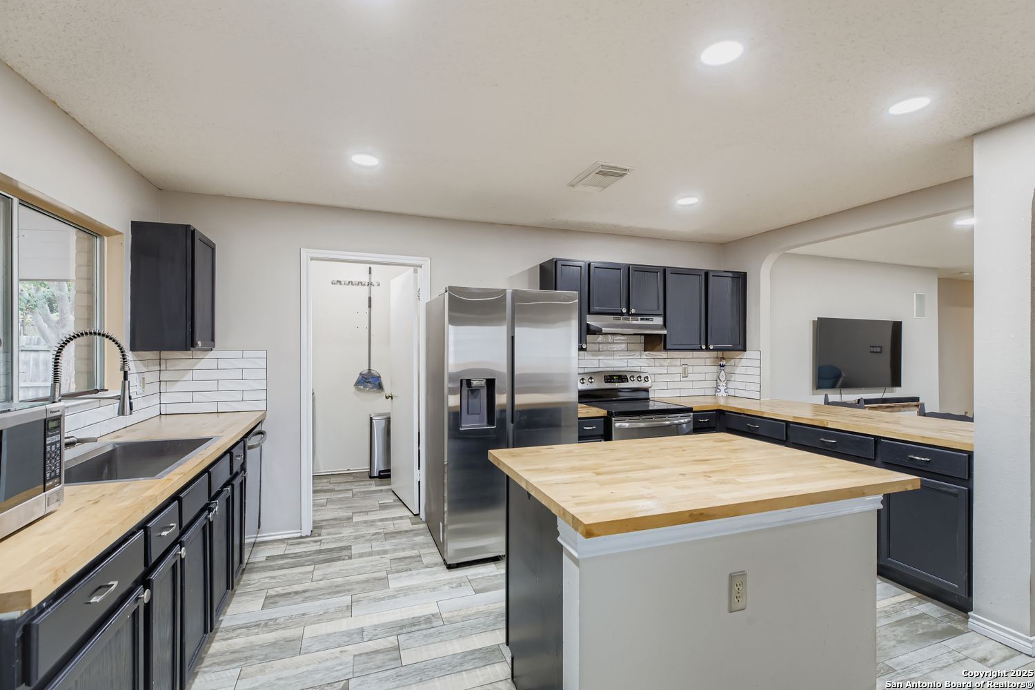 8614 Cross Spring San Antonio, TX 78251 - Photo 9 of 24 a kitchen with a sink a counter top space stainless steel appliances and cabinets