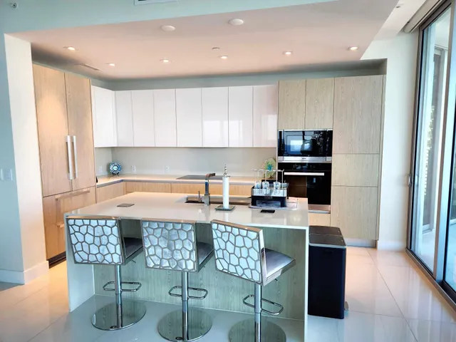 a kitchen with stainless steel appliances granite countertop a stove top oven a sink a counter space and cabinets