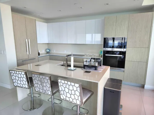 a kitchen with stainless steel appliances a table chairs and a refrigerator