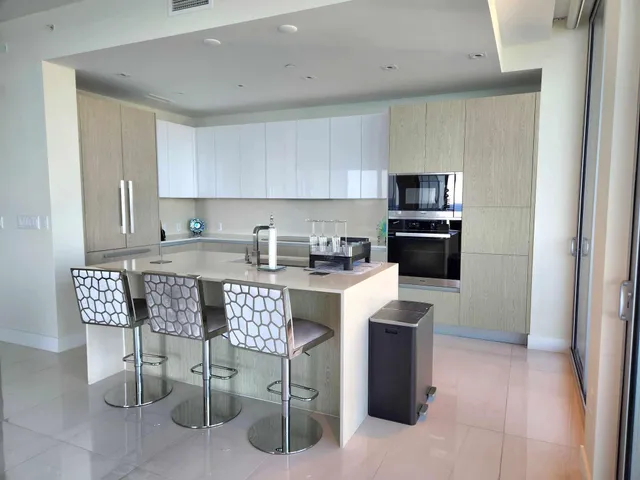 a kitchen with stainless steel appliances granite countertop a stove a sink a microwave and a refrigerator