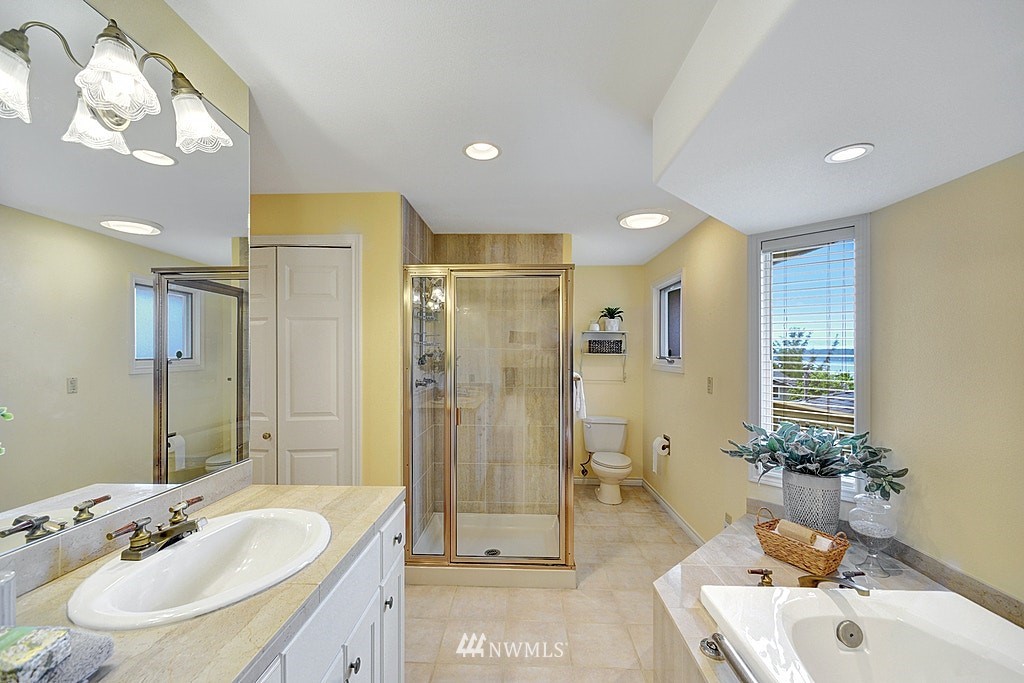 4402 Southwest Rose Street Seattle, WA 98136 - Photo 13 of 20 a bathroom with a tub sink mirror and shower