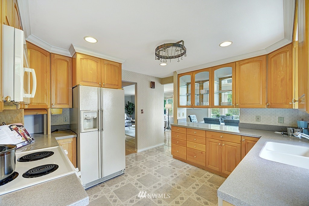 4402 Southwest Rose Street Seattle, WA 98136 - Photo 7 of 20 a kitchen with a refrigerator a sink and cabinets