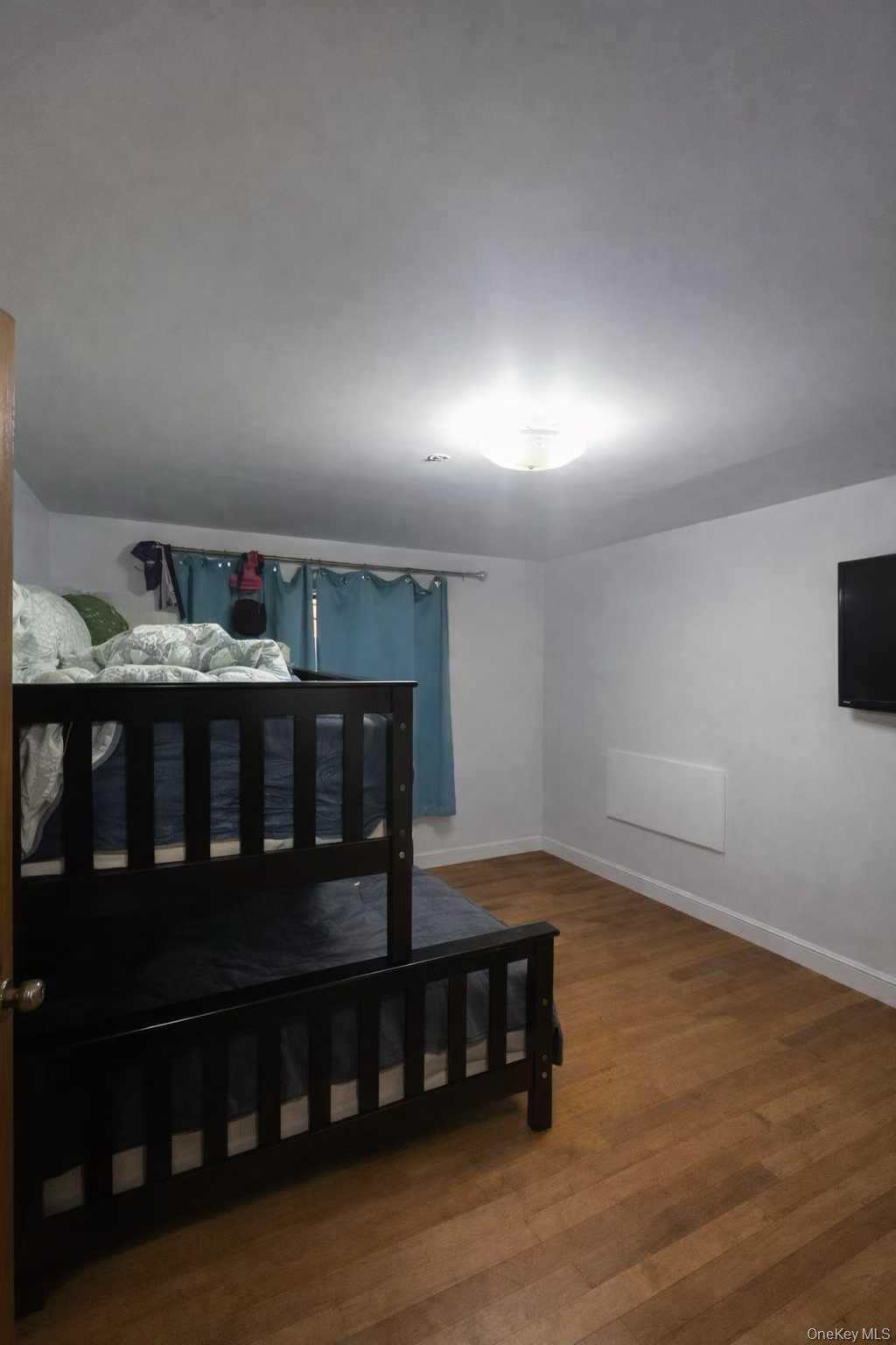 37-33 107th Street, Unit 4A Queens, NY 11368 - Photo 3 of 7 a view of wooden floor and windows in a room