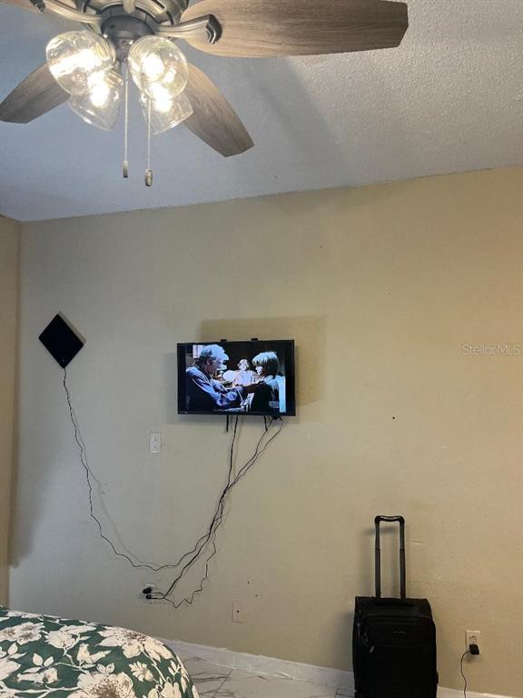 8421 South Orange Blossom Trail, Unit 248 Orlando, FL 32809 - Photo 3 of 10 a bedroom with a bed and a chandelier