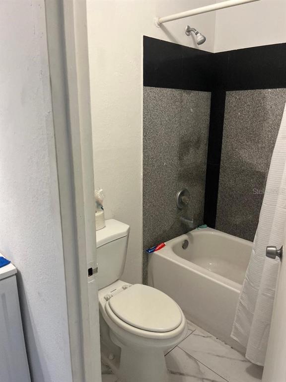 8421 South Orange Blossom Trail, Unit 248 Orlando, FL 32809 - Photo 8 of 10 a white toilet sitting next to a bathroom sink and a shower