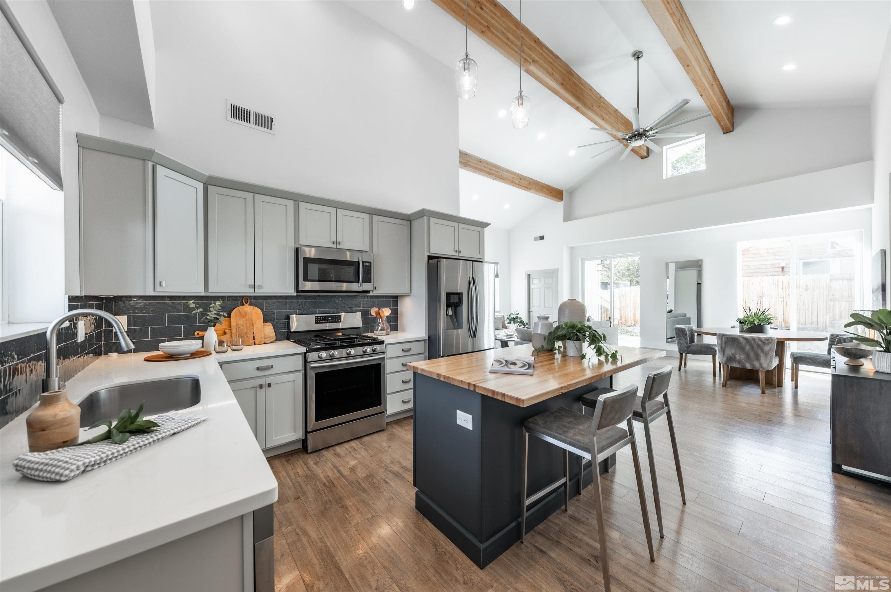 1217 Lander Street Reno, NV 89509 - Photo 2 of 21 a kitchen with stainless steel appliances granite countertop a stove top oven a sink dishwasher and white cabinets with wooden floor