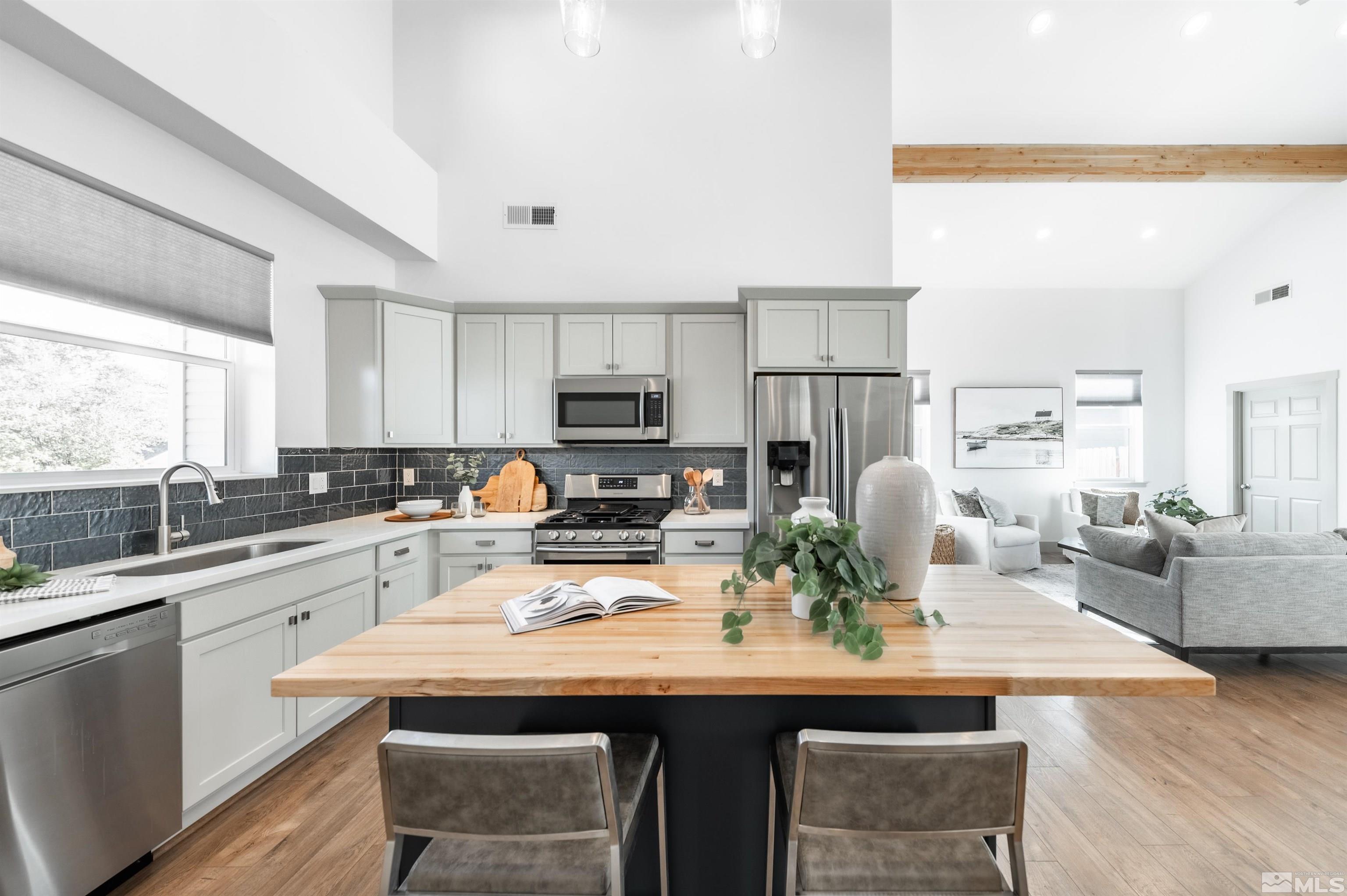 1217 Lander Street Reno, NV 89509 - Photo 3 of 21 a kitchen with stainless steel appliances kitchen island granite countertop a table chairs sink and cabinets