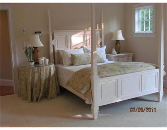 6 Rice Street, Unit 1 Wellesley, MA 02481 - Photo 5 of 8 a bedroom with a bed and a chandelier