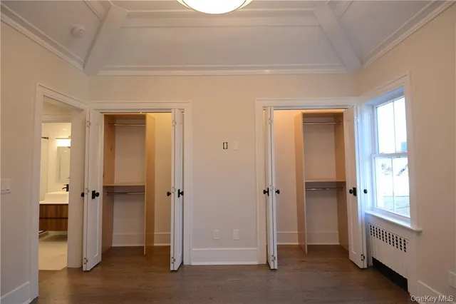 a view of an empty room with a window and bathroom