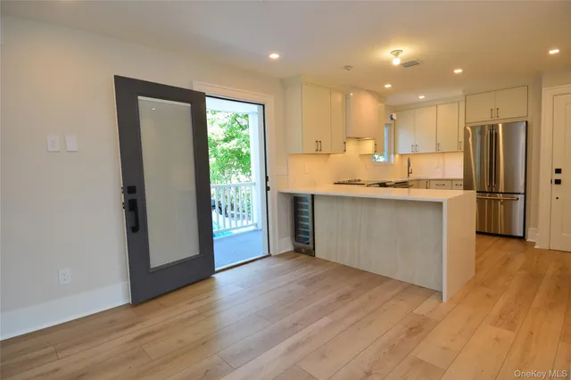 a kitchen with stainless steel appliances granite countertop a refrigerator a sink dishwasher and a stove with wooden floor