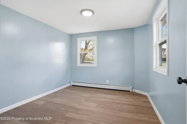 a front view of a house with a garden and trees