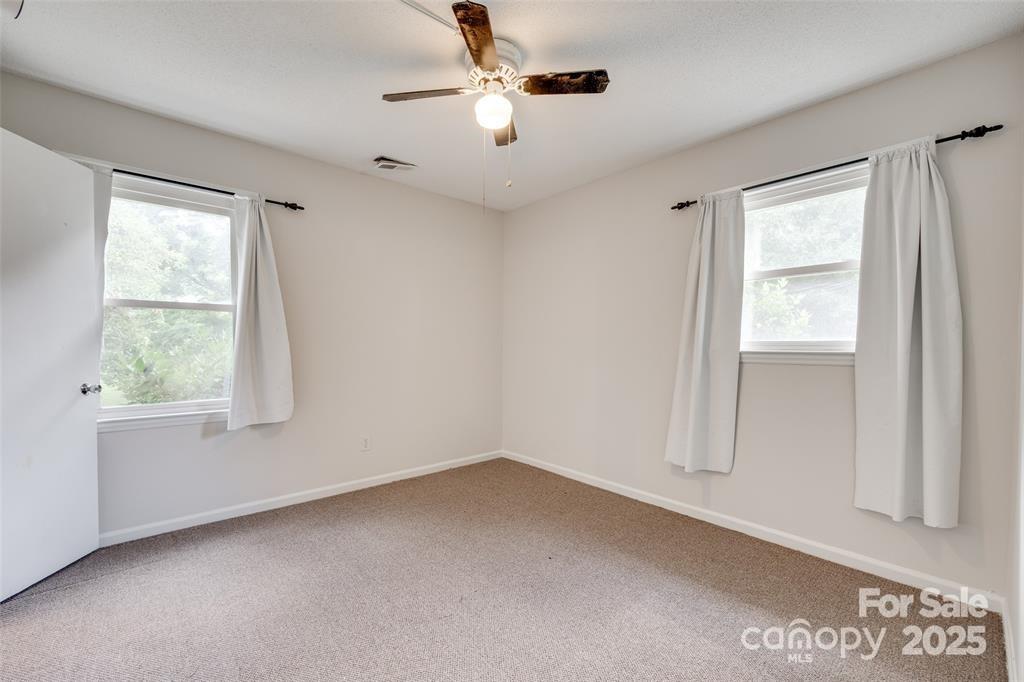 810 Applegate Court Gastonia, NC 28054 - Photo 12 of 31 an empty room with a window and a ceiling fan